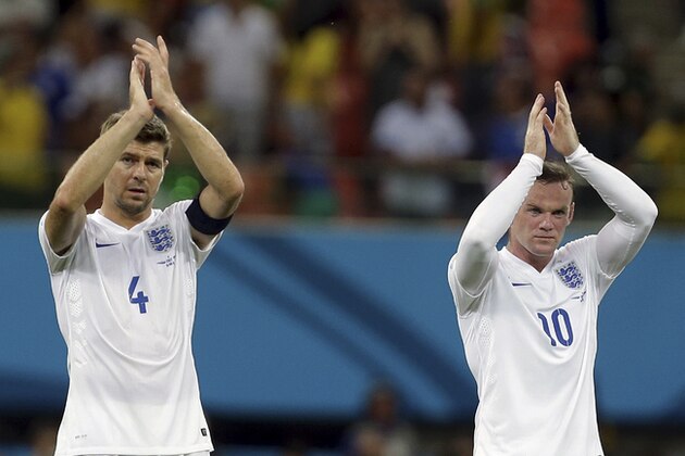 England's Steven Gerrard, left, and Wayne Rooney applaud spectators after the group D World Cup soccer match between England and Italy at the Arena da Amazonia in Manaus, Brazil, Saturday, June 14, 2014. Italy won the match 2-1.  (AP Photo/Martin Mejia)