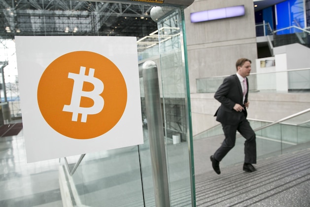 FILE - In this April 7, 2014 file photo, a man arrives for the Inside Bitcoins conference and trade show in New York. The Bitcoin digital currency system is in danger of losing its credibility as an independent payment system because of the growing power of a group that runs the some of the computers behind it. (AP Photo/Mark Lennihan, File)