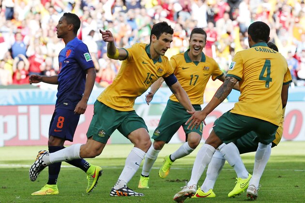 Australia's Mile Jedinak (15) celebrates with his teammates after kicking a penalty shot to score his side's second goal during the group B World Cup soccer match between Australia and the Netherlands at the Estadio Beira-Rio in Porto Alegre, Brazil, Wednesday, June 18, 2014. (AP Photo/Jon Super)