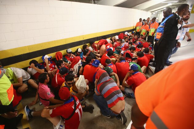 RIO DE JANEIRO, BRAZIL - JUNE 18:  Security personnel attempt to control fans after breaking through security and entering the stadium prior to the 2014 FIFA World Cup Brazil Group B match between Spain and Chile at Maracana on June 18, 2014 in Rio de Janeiro, Brazil.  (Photo by Julian Finney/Getty Images)