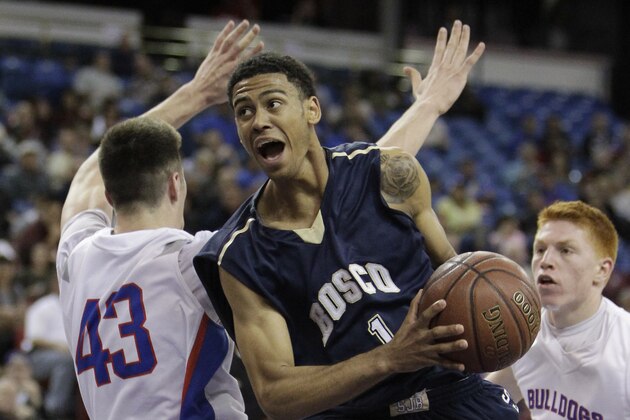 St. John Bosco guard Tyler Dorsey, center, eludes Folsom center Colin Russell on a drive to the basket during the third quarter of the boys' Division 2 CIF basketball championship game Saturday, March 29, 2014, in Sacramento, Calif. St. John Bosco won 63-54. (AP Photo/Rich Pedroncelli)