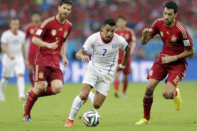 Chile's Alexis Sanchez, centre,  runs at the Spanish defence during the group B World Cup soccer match between Spain and Chile at the Maracana Stadium in Rio de Janeiro, Brazil, Wednesday, June 18, 2014.  (AP Photo/Bernat Armangue)