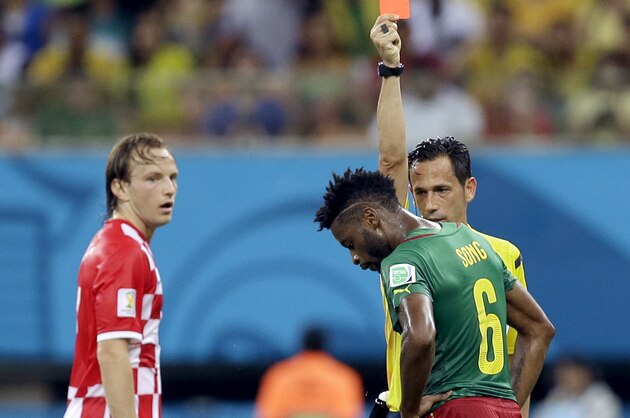 Referee Pedro Proenca from Portugal gives a red card to Cameroon's Alex Song as Croatia's Ivan Rakitic looks on during the group A World Cup soccer match between Cameroon and Croatia at the Arena da Amazonia in Manaus, Brazil, Wednesday, June 18, 2014.  (AP Photo/Themba Hadebe)