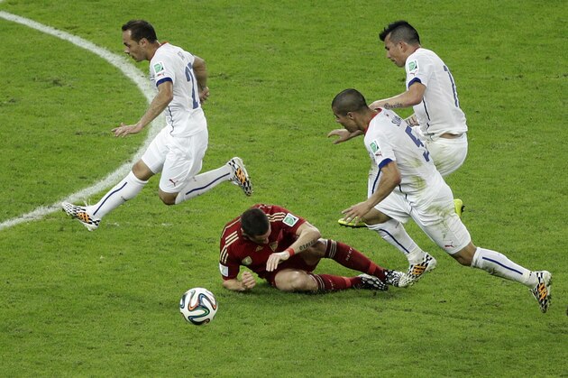 Chile's Eugenio Mena, Francisco Silva and Gary Medel, from left, jump over Spain's Fernando Torres during the group B World Cup soccer match between Spain and Chile at the Maracana Stadium in Rio de Janeiro, Brazil, Wednesday, June 18, 2014. Spain was eliminated from the World Cup with a 2-0 loss to Chile.  (AP Photo/Christophe Ena)