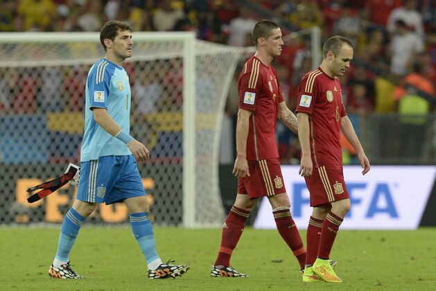 Spain's goalkeeper Iker Casillas,  Fernando Torres and Andres Iniesta leave the field after the group B World Cup soccer match between Spain and Chile at the Maracana Stadium in Rio de Janeiro, Brazil, Wednesday, June 18, 2014. Defending champion Spain was eliminated from the World Cup after losing to Chile 2-0.  (AP Photo/Manu Fernandez)