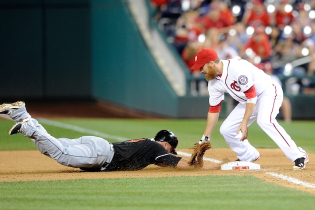WASHINGTON, DC - MAY 28:  Casey McGehee #9 of the Miami Marlins is picked off of first base in the eighth inning by Adam LaRoche #25 of the Washington Nationals at Nationals Park on May 28, 2014 in Washington, DC. Miami won the game 8-5 in ten innings.  (Photo by Greg Fiume/Getty Images)