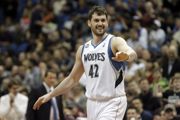 Minnesota Timberwolves' Kevin Love , left, congratulates Corey Brewer after Brewer's dunk in the first quarter of an NBA basketball game against the Detroit Pistons, Friday, March 7, 2014, in Minneapolis. (AP Photo/Jim Mone)