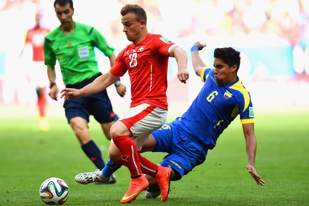 BRASILIA, BRAZIL - JUNE 15:  Christian Noboa of Ecuador tackles Xherdan Shaqiri of Switzerland during the 2014 FIFA World Cup Brazil Group E match between Switzerland and Ecuador at Estadio Nacional on June 15, 2014 in Brasilia, Brazil.  (Photo by Stu Forster/Getty Images)