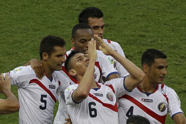 Costa Rica's Oscar Duarte, center, celebrates with teammates his side's 2nd goal during the group D World Cup soccer match between Uruguay and Costa Rica at the Arena Castelao in Fortaleza, Brazil, Saturday, June 14, 2014.  (AP Photo/Sergei Grits)