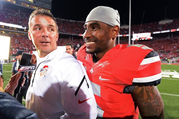 COLUMBUS, OH - SEPTEMBER 28:  Quarterback Braxton Miller #5 of the Ohio State Buckeyes sneaks up on Head Coach Urban Meyer of the Ohio State Buckeyes while Meyer is being interviewed for television after the Buckeyes defeated the Wisconsin Badgers 31-24 at Ohio Stadium on September 28, 2013 in Columbus, Ohio.  (Photo by Jamie Sabau/Getty Images)