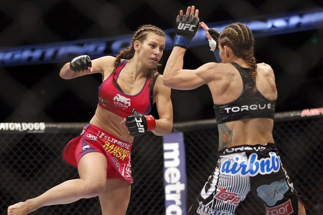 Miesha Tate, left, and Liz Carmouche fight in a mixed martial arts event on Saturday, April 19, 2014, at UFC Fight Night in Orlando Fla. Tate defeated Carmouche. (AP Photo/Reinhold Matay)