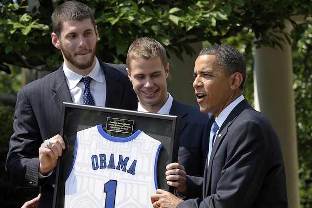 President Barack Obama receives a framed Duke University jersey from players Brian Zoubek, left, and Jon Scheyer, center, of the NCAA Men's Basketball Champion Duke Blue Devils, Thursday, May 27, 2010, in the Rose Garden of the White House in Washington, where the president honored the NCAA champion basketball team.  (AP Photo/Susan Walsh)