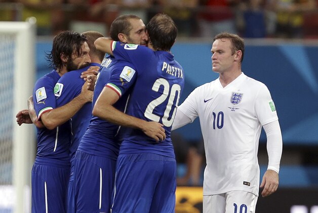 England's Wayne Rooney, right, looks on as Italy's Gabriel Paletta, center, and other Italian players celebrate after the group D World Cup soccer match between England and Italy at the Arena da Amazonia in Manaus, Brazil, Saturday, June 14, 2014. Italy won the match 2-1.  (AP Photo/Martin Mejia)