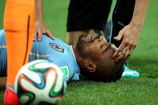 SAO PAULO, BRAZIL - JUNE 19:  Alvaro Pereira of Uruguay receives treatment during the 2014 FIFA World Cup Brazil Group D match between Uruguay and England at Arena de Sao Paulo on June 19, 2014 in Sao Paulo, Brazil.  (Photo by Richard Heathcote/Getty Images)