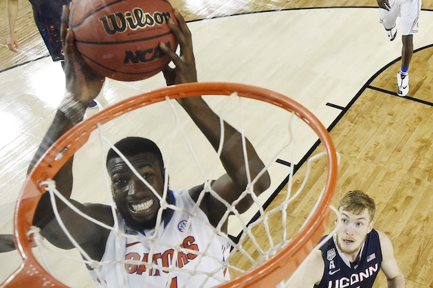 Florida center Patric Young (4) dunks as Connecticut guard/forward Niels Giffey (5) looks on during the second half of the NCAA Final Four tournament college basketball semifinal game Saturday, April 5, 2014, in Arlington, Texas. (AP Photo/Chris Steppig, pool)