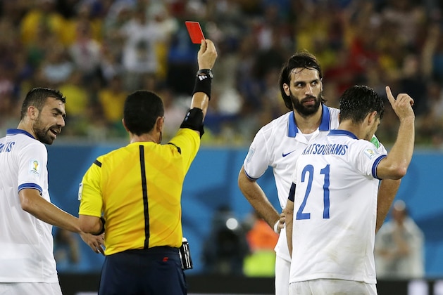 Greece's Kostas Katsouranis (21) gestures at referee Joel Aguilar from El Salvador after being sent off with a red card during the group C World Cup soccer match between Japan and Greece at the Arena das Dunas in Natal, Brazil, Thursday, June 19, 2014.  (AP Photo/Shuji Kajiyama)