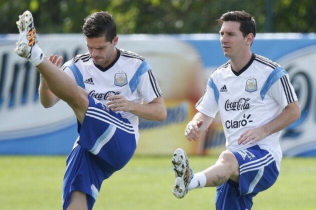 Argentina's Fernando Gago, left, and teammate Lionel Messi warm up at a training session in Vespasiano, near Belo Horizonte, Brazil, Wednesday, June 18, 2014.  Argentina plays in group F of the 2014 soccer World Cup. (AP Photo/Victor R. Caivano)
