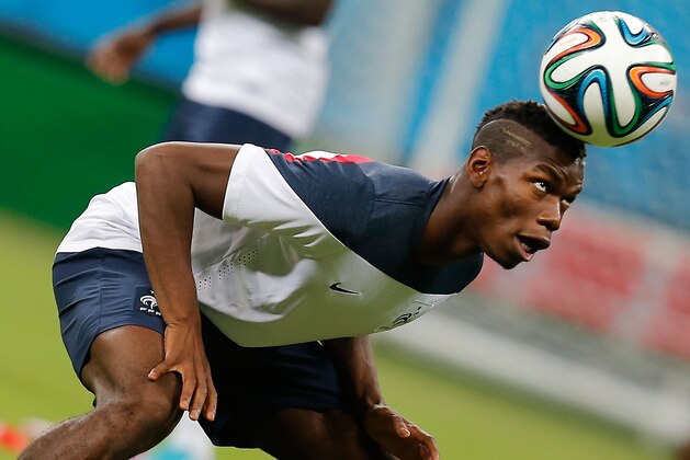 France's midfielder Paul Pogba heads the ball during an official training session the day before the group E World Cup soccer match between France and Switzerland at the Arena Fonte Nova stadium in Salvador, Brazil, Thursday, June 19, 2014. (AP Photo/David Vincent)