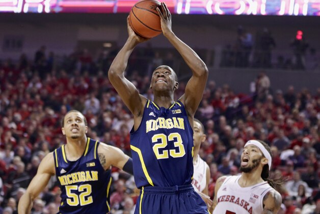 Michigan's Caris LeVert (23) goes for a layup as Nebraska's Terran Petteway (5) and Michigan's Jordan Morgan (52) look on in the first half of an NCAA college basketball game in Lincoln, Neb., Thursday, Jan. 9, 2014. (AP Photo/Nati Harnik)