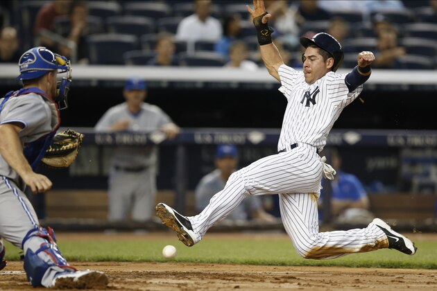 New York Yankees Jacoby Ellsbury, right, slides in with the throw in front of his foot as Toronto Blue Jays catcher Erik Kratz, left, prepares for the tag in the third inning of  a baseball game at Yankee Stadium in New York, Thursday, June 19, 2014.  Ellsbury scored on the play and the Yankees went on to win 6-4. (AP Photo/Kathy Willens)