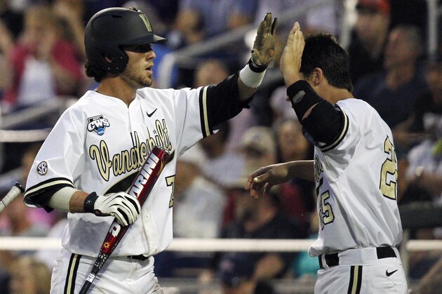 Jun 14, 2014; Omaha, NE, USA; Vanderbilt Commodores catcher Karl Ellison (25) celebrates with runner Dansby Swanson (7) after Swanson scored against the Louisville Cardinals during game two of the 2014 College World Series at TD Ameritrade Park Omaha. Vanderbilt won 5-3. Mandatory Credit: Bruce Thorson-USA TODAY Sports