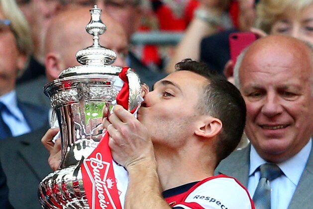 LONDON, ENGLAND - MAY 17:  Captain Thomas Vermaelen of Arsenal (R) kisses the trophy in celebration as FA chairman Greg Dyke looks on after the FA Cup with Budweiser Final match between Arsenal and Hull City at Wembley Stadium on May 17, 2014 in London, England.  (Photo by Clive Mason/Getty Images)