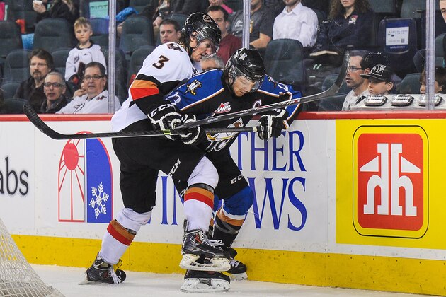 CALGARY, AB - MARCH 15: Kenton Helgesen #3 of the Calgary Hitmen checks Sam Reinhart #23 of the Kootenay Ice during a WHL game at Scotiabank Saddledome on March 15, 2014 in Calgary, Alberta, Canada. (Photo by Derek Leung/Getty Images)