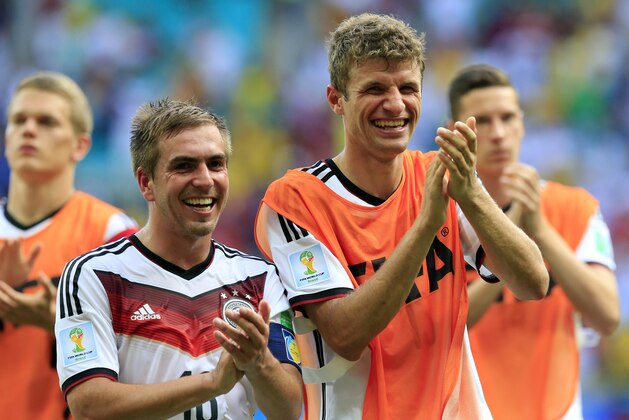 Germany's Philipp Lahm, left, and Thomas Mueller applaud after the group G World Cup soccer match between Germany and Portugal at the Arena Fonte Nova in Salvador, Brazil, Monday, June 16, 2014.  Germany won the match 4-0.  (AP Photo/Bernat Armangue)