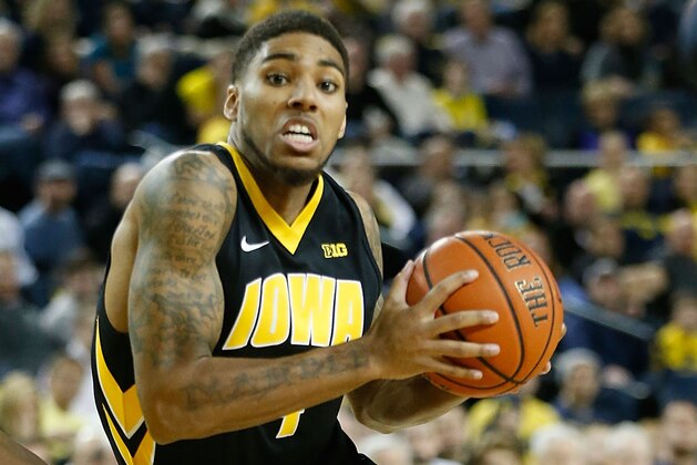 ANN ARBOR, MI - JANUARY 22: Roy Devyn Marble #4 of the Iowa Hawkeyes drives the ball to the basket as Caris Levert #23 of the Michigan Wolverines defends during the second half of the game at Crisler Arena on January 22, 2014 in Ann Arbor, Michigan. The Wolverines defeated the Hawkeyes 75-67. (Photo by Leon Halip/Getty Images)