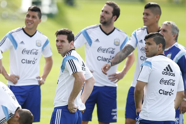 Argentina's Lionel Messi, second left, teammate Sergio Aguero, right, and other teammates gather at the start of a training session in Vespasiano, near Belo Horizonte, Brazil, Wednesday, June 18, 2014.  Argentina plays in group F of the 2014 soccer World Cup. (AP Photo/Victor R. Caivano)