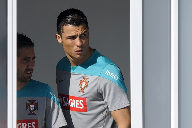 Cristiano Ronaldo and Joao Moutinho, left, peek from the dressing room prior to a training session of Portugal in Campinas, Brazil, Friday, June 20, 2014. Portugal plays in group G of the Brazil 2014 soccer World Cup. (AP Photo/Paulo Duarte)