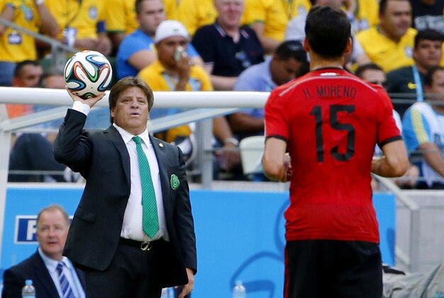 Jun 17, 2014; Fortaleza, Ceara, BRAZIL; Mexico manager Miguel Herrera tosses the ball to Mexico defender Hector Moreno (15) during the first half of the 2014 World Cup game against Brazil at Estadio Castelao. Mandatory Credit: Winslow Townson-USA TODAY Sports