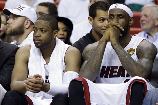 Miami Heat forward LeBron James, right and guard Dwyane Wade sit on the bench during the last minutes in the second half in Game 4 of the NBA basketball finals against the San Antonio Spurs, Thursday, June 12, 2014, in Miami.  The Spurs defeated the Heat 107-86. (AP Photo/Lynne Sladky)