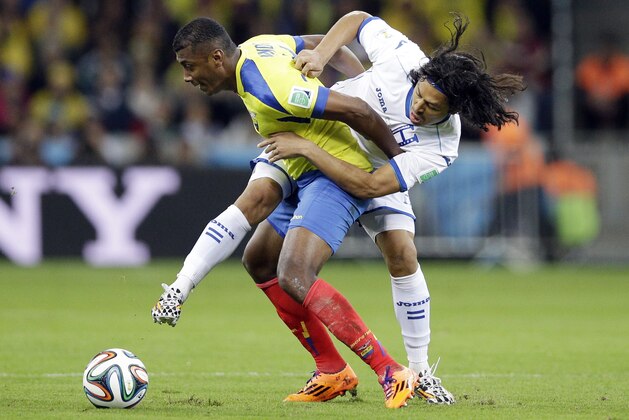 Honduras' Roger Espinoza, right, battles for the ball with Ecuador's Walter Ayovi during the group E World Cup soccer match at the Arena da Baixada in Curitiba, Brazil, Friday, June 20, 2014. (AP Photo/Michael Sohn)