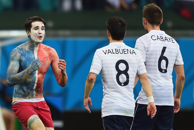 SALVADOR, BRAZIL - JUNE 20: A pitch invader runs woard Mathieu Valbuena and Yohan Cabaye of France during the 2014 FIFA World Cup Brazil Group E match between Switzerland and France at Arena Fonte Nova on June 20, 2014 in Salvador, Brazil.  (Photo by Christopher Lee/Getty Images)