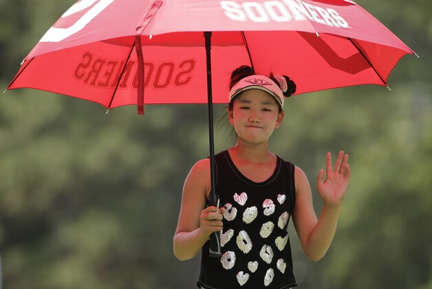 Lucy Li waves at fans on the second hole during the second round of the U.S. Women's Open golf tournament in Pinehurst, N.C., Friday, June 20, 2014. (AP Photo/Chuck Burton)