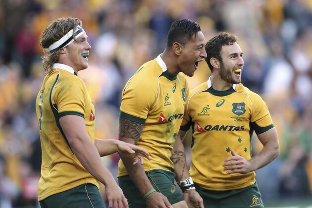 Australia's Israel Folaua, center, celebrates with his teammates Michael Hooper, left, and Nic White after scoring a try during their Rugby Test Match against France in Sydney, Australia, Saturday, June 21, 2014. (AP Photo/Rob Griffith)