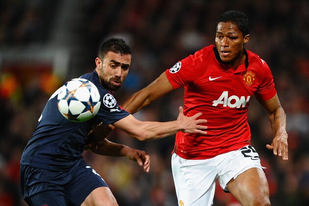 MANCHESTER, ENGLAND - MARCH 19:  Antonio Valencia of Manchester United competes with Giannis Maniatis of Olympiacos during the UEFA Champions League Round of 16 second round match between Manchester United and Olympiacos FC at Old Trafford on March 19, 2014 in Manchester, England.  (Photo by Laurence Griffiths/Getty Images)