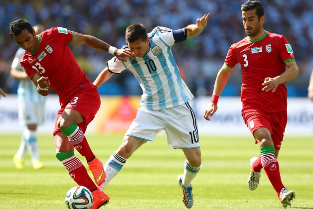 BELO HORIZONTE, BRAZIL - JUNE 21:  Mehrdad Pooladi of Iran and Lionel Messi of Argentina compete for the ball during the 2014 FIFA World Cup Brazil Group F match between Argentina and Iran at Estadio Mineirao on June 21, 2014 in Belo Horizonte, Brazil.  (Photo by Quinn Rooney/Getty Images)