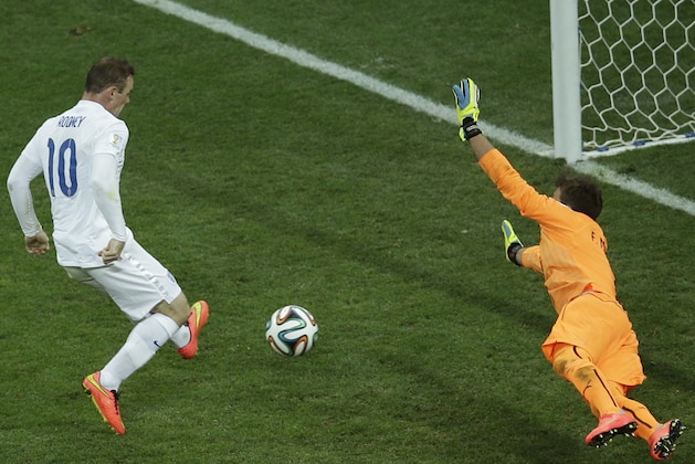England's Wayne Rooney, left, scores his side's first goal past Uruguay's goalkeeper Fernando Muslera during the group D World Cup soccer match between Uruguay and England at the Itaquerao Stadium in Sao Paulo, Brazil, Thursday, June 19, 2014.  (AP Photo/Michael Sohn)