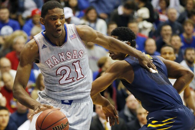 Kansas center Joel Embiid (21) pushes off West Virginia forward Devin Williams, right, during the first half of an NCAA college basketball game in Lawrence, Kan., Saturday, Feb. 8, 2014. Embiid scored 11 points in the game. Kansas defeated West Virginia 83-69. (AP Photo/Orlin Wagner)