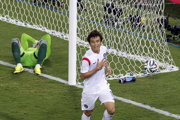 Russia's goalkeeper Igor Akinfeev, left, lies in the goal as South Korea's Koo Ja-cheol celebrates after scoring the opening goal during their group H World Cup soccer match at the Arena Pantanal in Cuiaba, Brazil, Tuesday, June 17, 2014. (AP Photo/Thanassis Stavrakis)