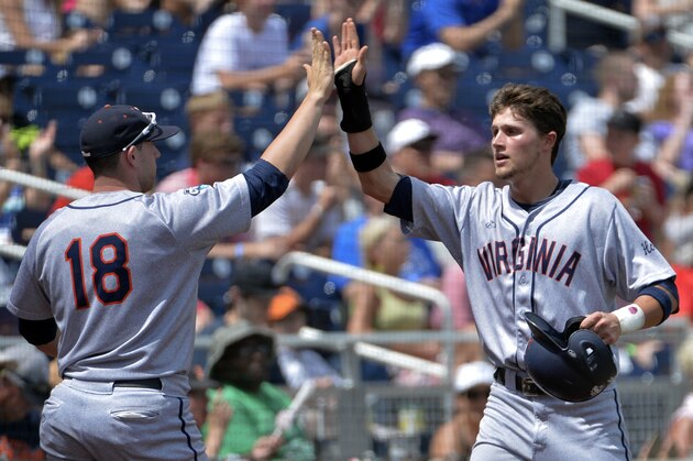 Virginia's Brandon Downes, right, celebrates with Nate Irving (18) after he scored against Mississippi on a two-run single by Robbie Coman in the fourth inning of an NCAA College World Series baseball game in Omaha, Neb., Saturday, June 21, 2014. (AP Photo/Ted Kirk)