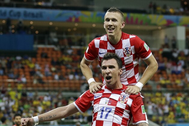 Croatia's Mario Mandzukic (17) celebrates with teammate Ivan Perisic after scoring his side's fourth goal during the group A World Cup soccer match between Cameroon and Croatia at the Arena da Amazonia in Manaus, Brazil, Wednesday, June 18, 2014.   (AP Photo/Martin Mejia)
