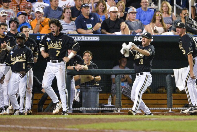 Vanderbilt payers Ro Coleman (1), Dansby Swanson (7), Tyler Beede (11) and Brian Miller, right, cheer on teammate Zander Wiel, unseen, after he scored in the fifth inning on a hit by Rhett Wiseman in the fifth inning of an NCAA baseball College World Series game against Texas in Omaha, Neb., Saturday, June 21, 2014. (AP Photo/Ted Kirk)