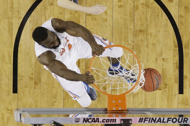 Florida center Patric Young (4) dunks as Connecticut guard/forward Niels Giffey (5) looks on during the second half of the NCAA Final Four tournament college basketball semifinal game Saturday, April 5, 2014, in Arlington, Texas. (AP Photo/David J. Phillip)