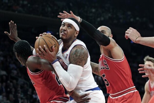 RETRANSMISSION TO CORRECT ID - Chicago Bulls forward Tony Snell (20) and Bulls forward Carlos Boozer (5) smother New York Knicks forward Carmelo Anthony (7) who tries to free himself from their defense in the first half of their NBA basketball game at Madison Square Garden in New York, Wednesday, Dec. 11, 2013. Anthony scored 30 points as the Knicks defeated the Bulls 83-78. (AP Photo/Kathy Willens)
