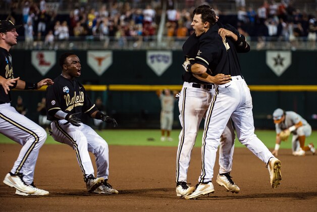 Jun 21, 2014; Omaha, NE, USA; Teammate mob Vanderbilt Commodores infielder Tyler Campbell (2) celebrates after driving in the winning run against the Texas Longhorns during game thirteen of the 2014 College World Series at TD Ameritrade Park Omaha. Vanderbilt defeated Texas 4-3 in ten innings. Mandatory Credit: Steven Branscombe-USA TODAY Sports