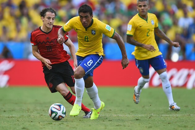 FORTALEZA, BRAZIL - JUNE 17:  Paulinho of Brazil takes on Andres Guardado of Mexico during the 2014 FIFA World Cup Brazil Group A match between Brazil and Mexico at Castelao on June 17, 2014 in Fortaleza, Brazil.  (Photo by Laurence Griffiths/Getty Images)