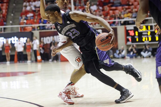 Washington's C.J. Wilcox (23) drives to the basket as Utah's Brandon Taylor, rear, defends in the second half of an NCAA college basketball game Thursday, Feb. 6, 2014, in Salt Lake City. (AP Photo/Rick Bowmer)